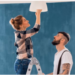 A couple changing a light fixture as part of home staging maintenance, ensuring proper lighting before listing the home.
