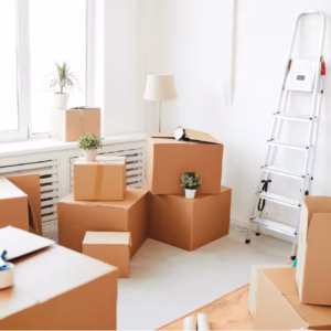 A room filled with moving boxes and minimal furniture, showing the decluttering process in home staging for a clean, organized look.