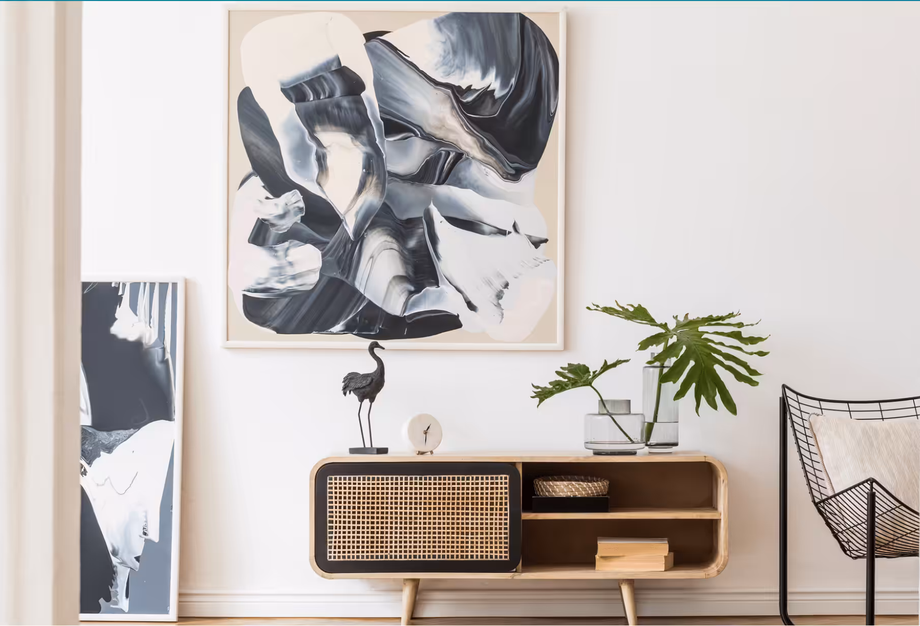 Stylishly staged living room featuring modern abstract wall art, wooden sideboard, decorative flamingo sculpture, and green plant accents. Designed by Live in Taste Interior Designers in Paarl, showcasing a minimalist approach to home staging with contemporary furnishings and natural decor elements.